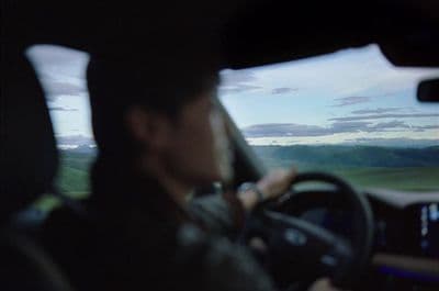 a man driving a car on a highway