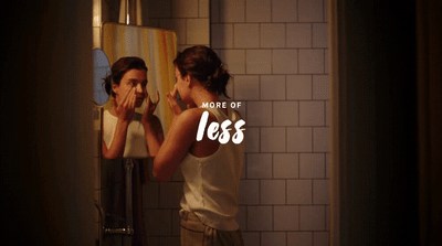 a woman brushing her teeth in front of a mirror