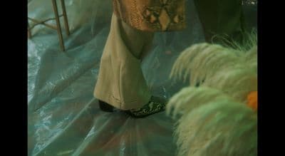 a close up of a person's shoes on a plastic sheet
