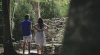 a man and a woman standing in a forest