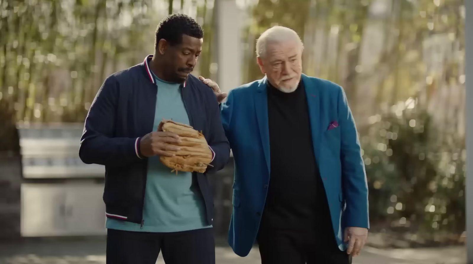 a man holding a baseball glove next to another man