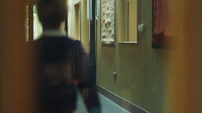 a blurry photo of a man walking down a hallway