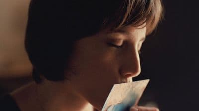 a woman holding a piece of paper in her mouth