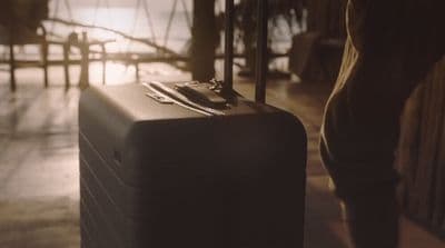 a person standing next to a piece of luggage