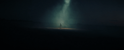 a person standing in the middle of a dark field