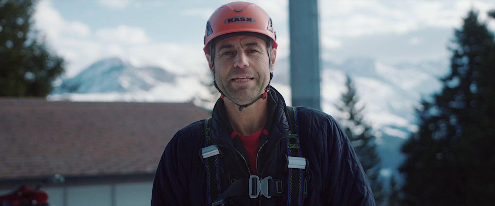 a man wearing a helmet standing in front of a building