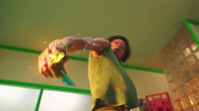 a man in a green shirt is holding a green object