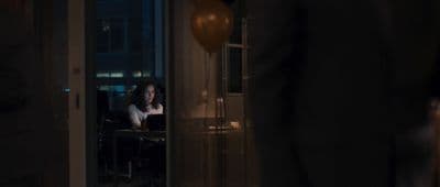 a woman sitting at a table in a dark room