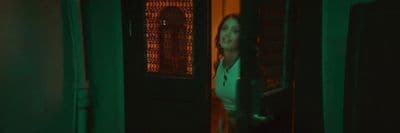 a woman standing in front of a green door