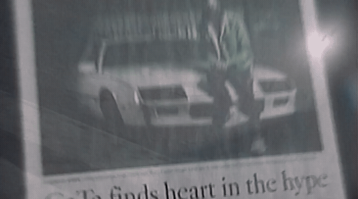 a newspaper with a picture of a man standing next to a car