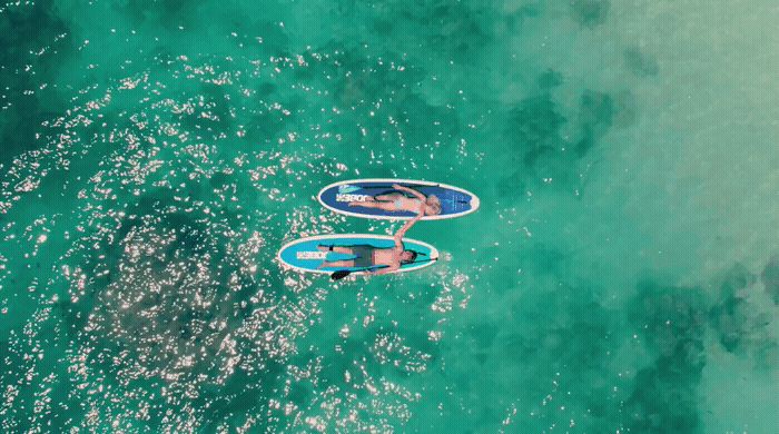 a couple of people riding on top of surfboards in the ocean