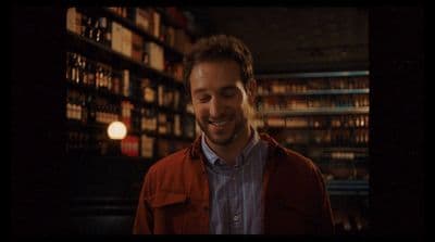 a man standing in front of a book shelf