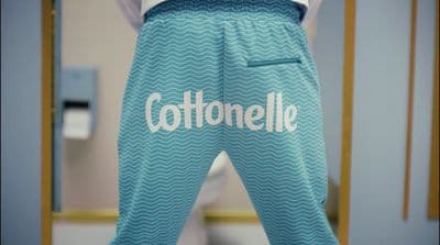 a person wearing a blue pajama pants with the word cottonelle on it