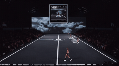 a woman walking across a tennis court in front of a crowd