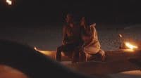 a couple of people sitting on top of a wooden bench