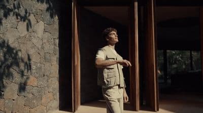a man standing in front of a stone building