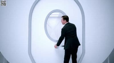 a man in a suit looking out of a window