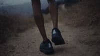 a person walking down a dirt road with their shoes on