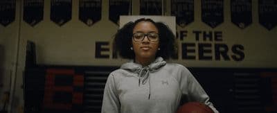 a woman holding a basketball in a gym