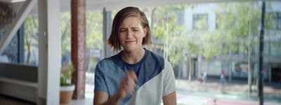 a woman standing in front of a window with her eyes closed