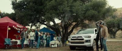a group of people standing around a white truck