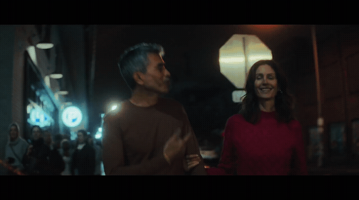 a man standing next to a woman on a street
