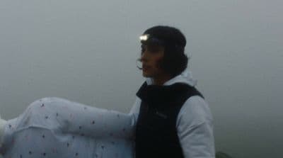 a man holding a white frisbee on a foggy day