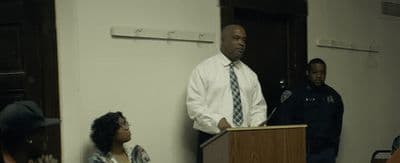 a man standing at a podium in front of a group of people