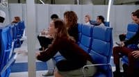 a group of people sitting on blue seats in a room