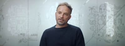 a man standing in front of a white wall