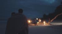 a man and a woman walking down a street at night