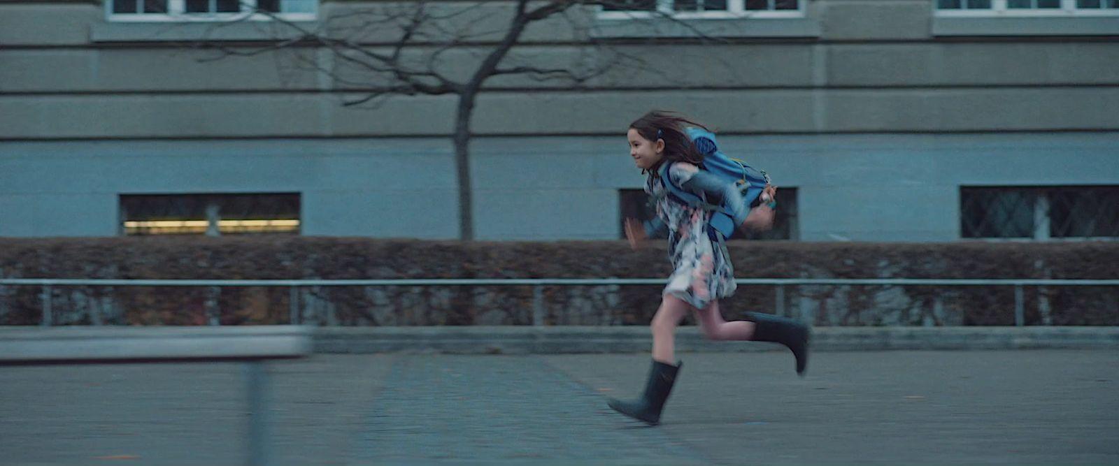 a woman with a backpack running down a sidewalk