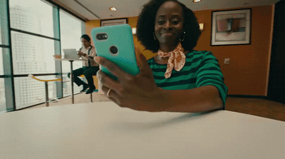 a woman sitting at a table holding a cell phone