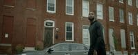 a man standing next to a car in front of a building