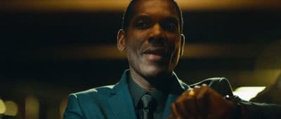 a man in a suit and tie standing in a dark room