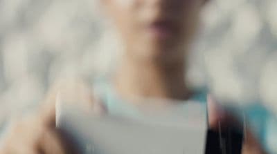 a blurry photo of a woman holding a piece of paper