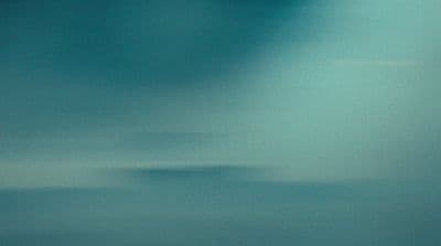 a plane flying in the sky with a cloud in the background