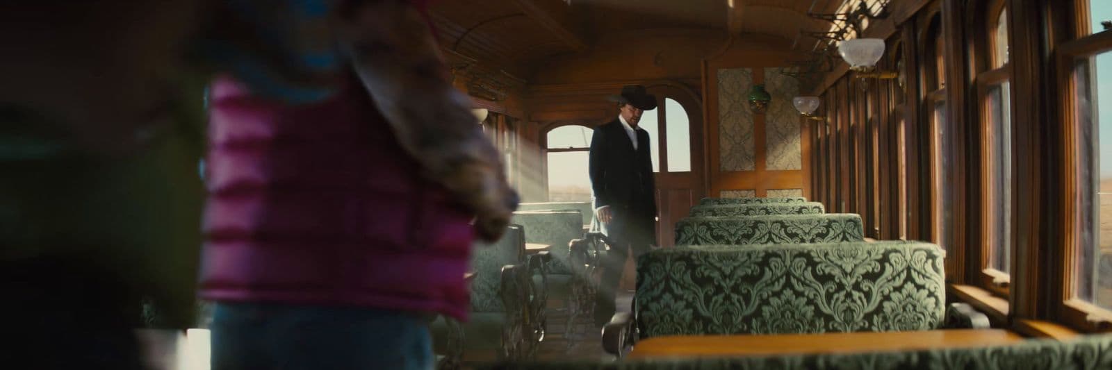 a man standing on a train looking out the window