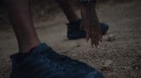 a close up of a person's foot with their hands in the air