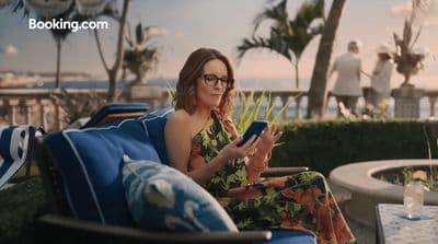 a woman sitting in a chair looking at a tablet