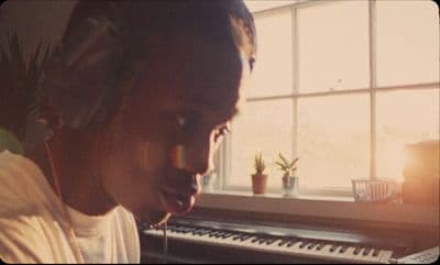 a person with headphones on in front of a keyboard