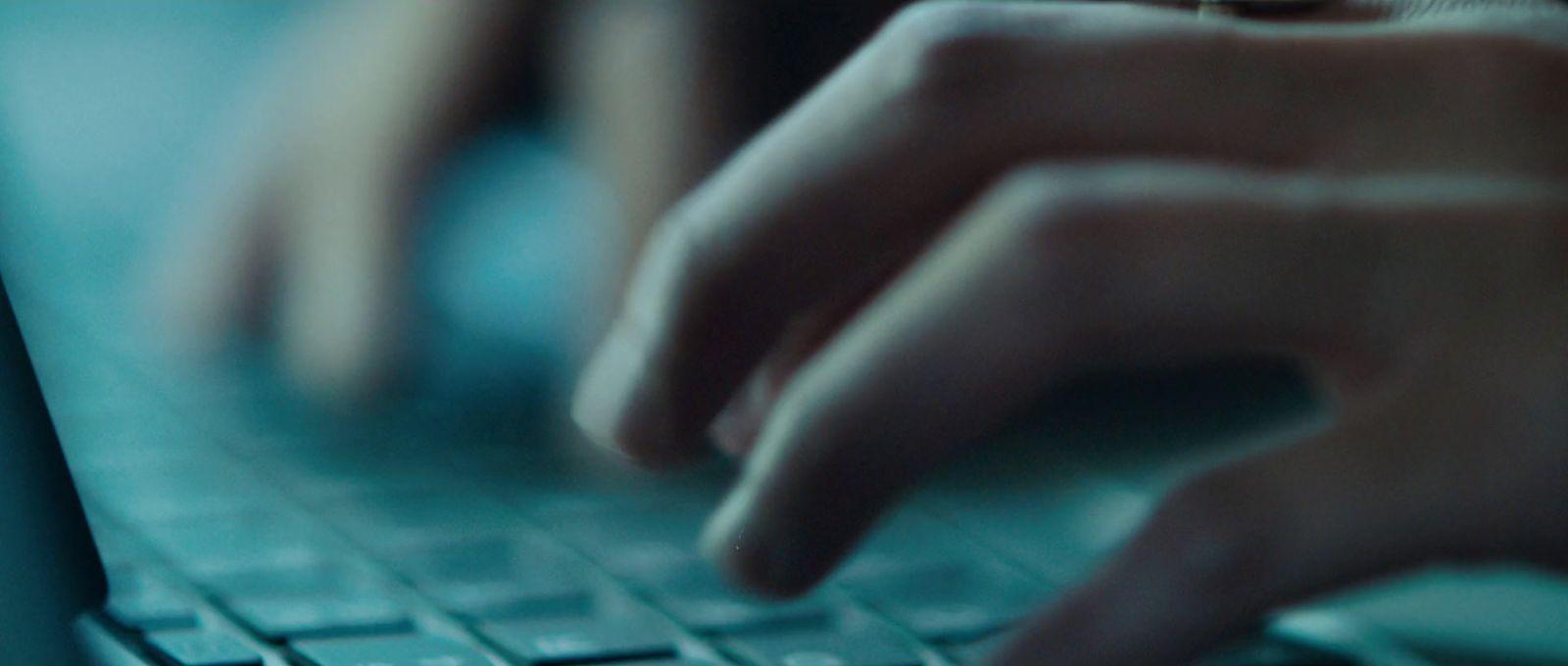 a close up of a person typing on a laptop