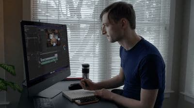 a man sitting in front of a computer monitor
