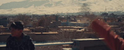 a man standing on top of a building next to a snow covered mountain
