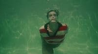 a woman in a red and white striped shirt under water