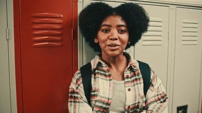 a woman standing in front of lockers in a locker