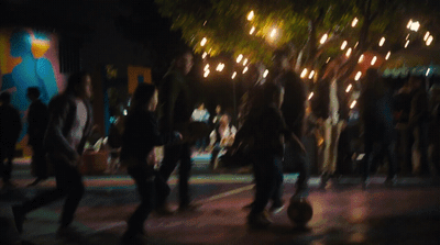 a group of people walking down a street at night