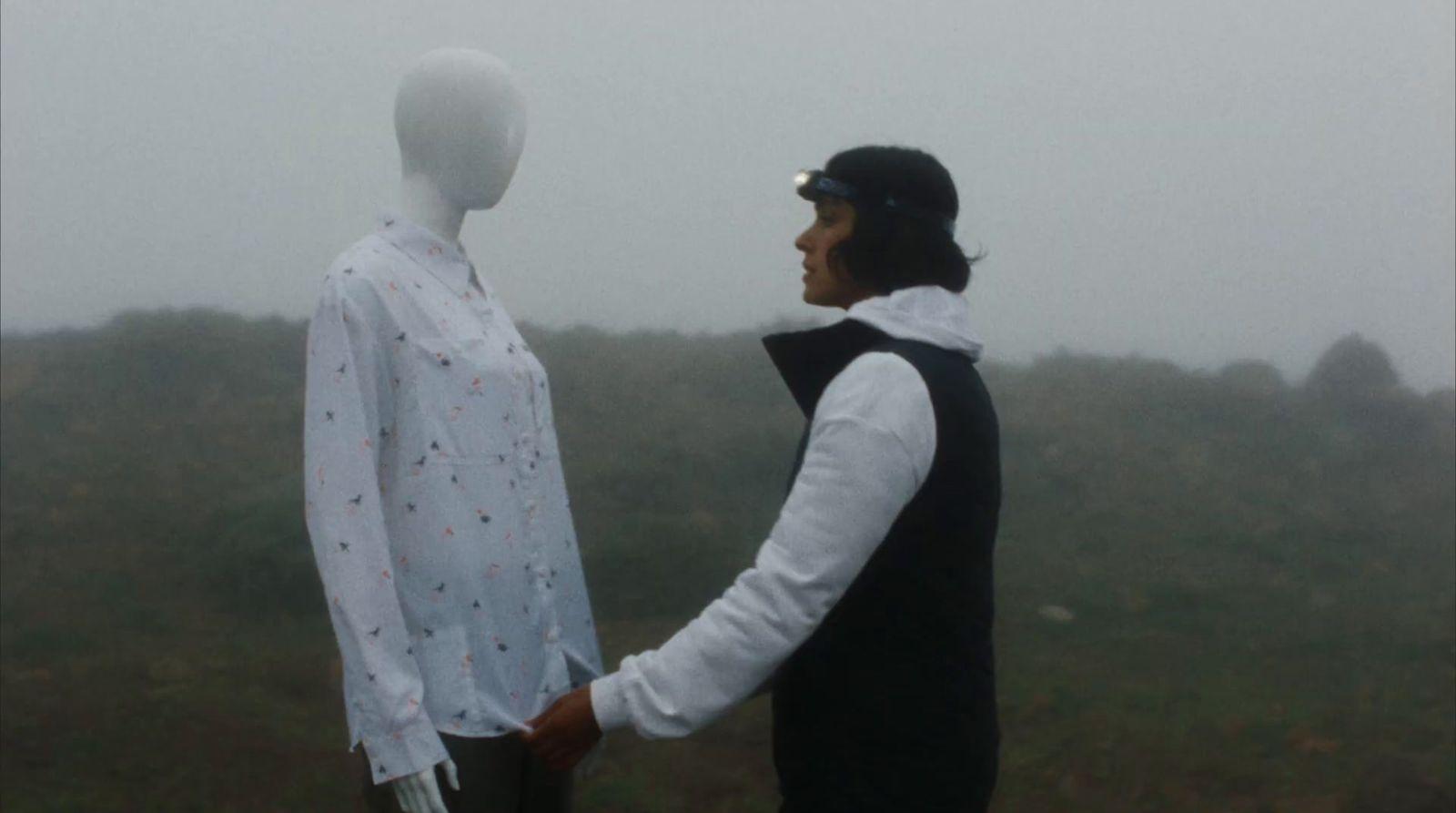 a man shaking hands with a mannequin in the fog
