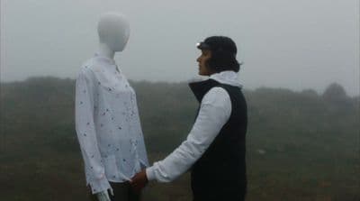 a man shaking hands with a mannequin in the fog
