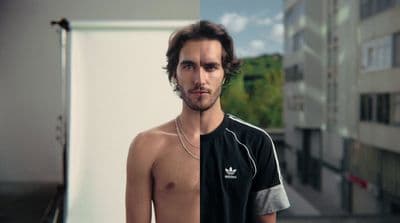 a man with no shirt standing in front of a building